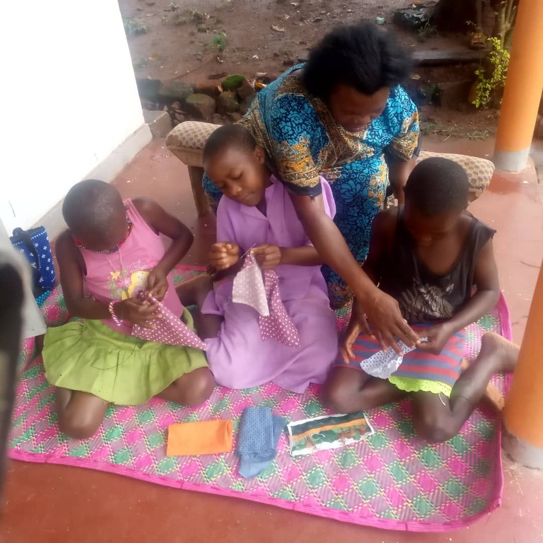 A mentor sitting with girls during a skills session