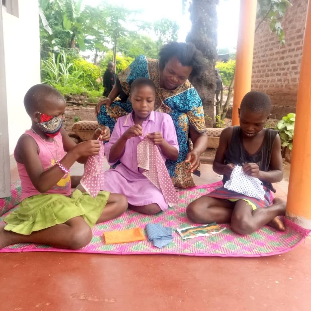 Girls learning a craft skill with a mentor